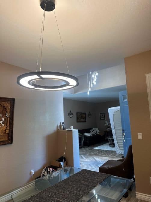 Modern circular pendant light above a dining table in a stylish interior setting.