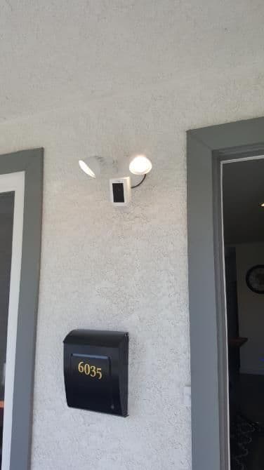 Exterior home entrance featuring a dual spotlight and black mailbox with the number 6035.