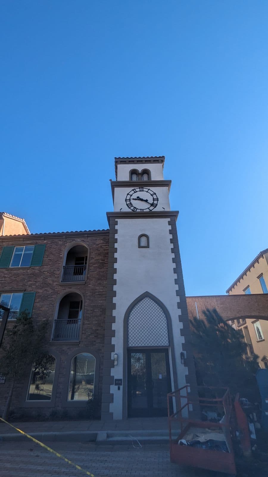 Clock tower building with arched entrance and blue sky backdrop.
