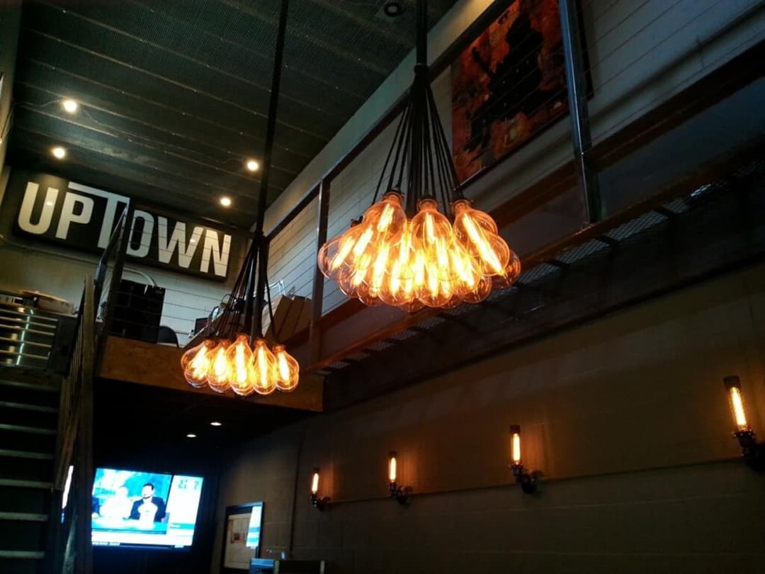Stylish industrial lighting fixture with vintage bulbs in modern interior cafe.