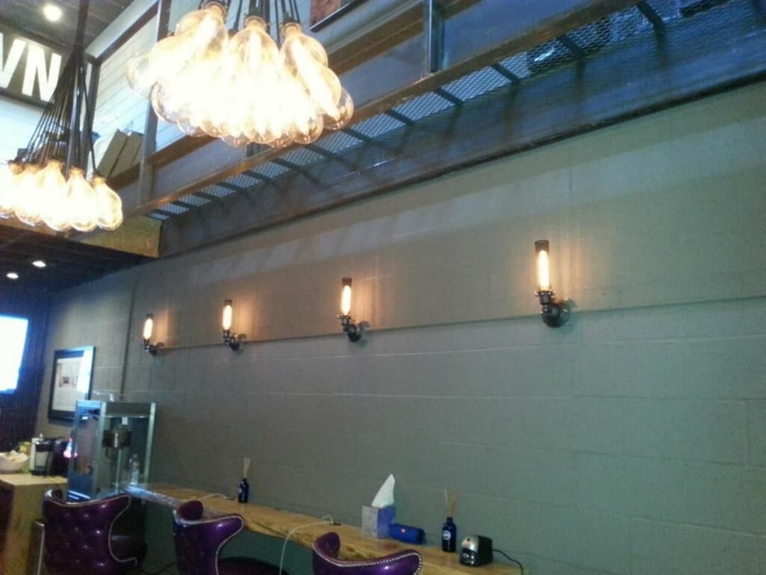 Industrial-style interior featuring Edison bulb lights and a wooden table in a modern space.
